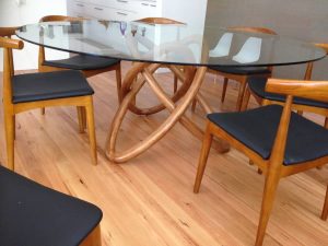 Glass top table with curved timber legs